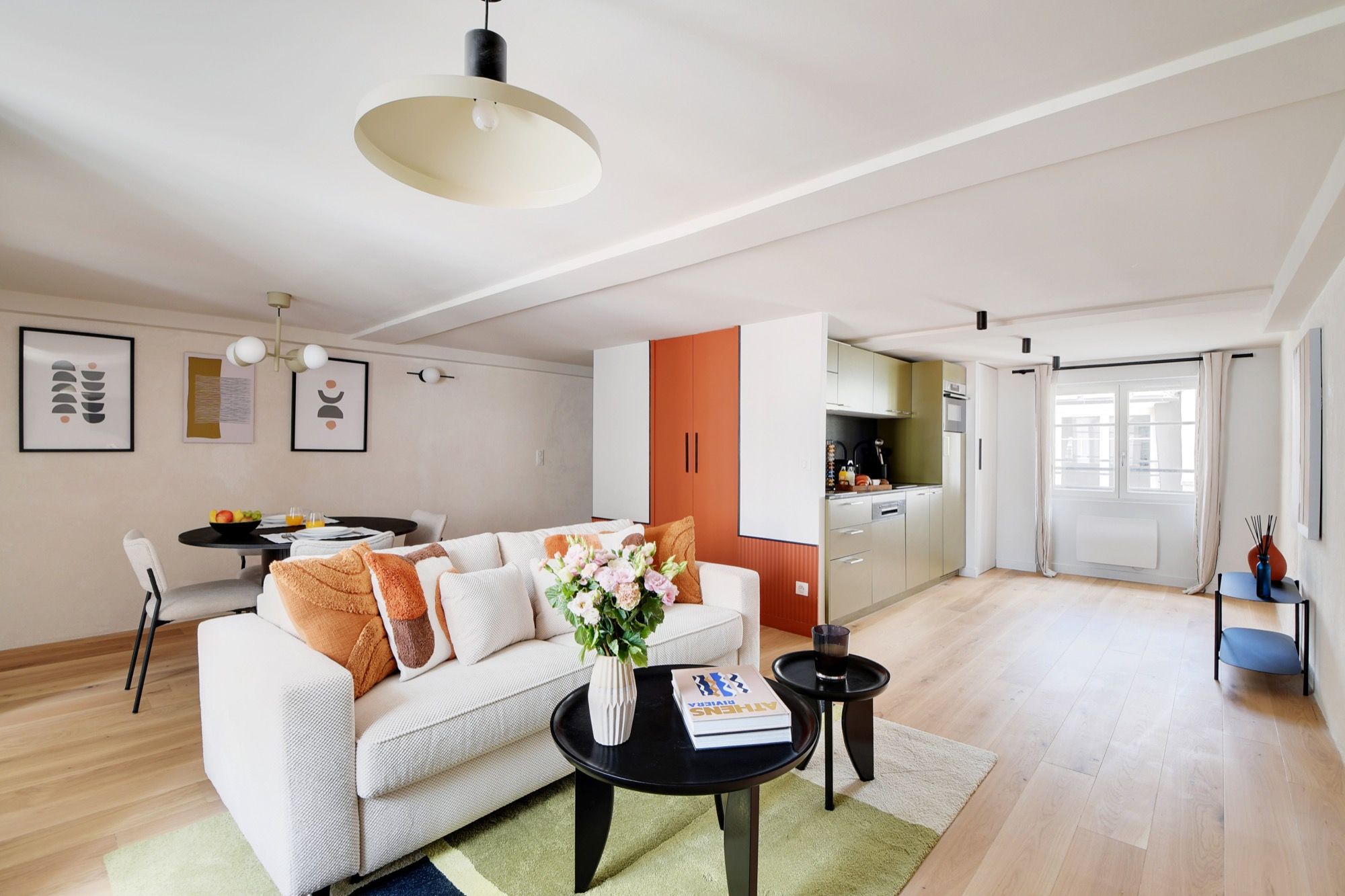 Un salon moderne comprenant un canapé, une table basse et un coin repas avec une table et des chaises.