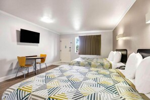 Une chambre d’hôtel équipée d’un lit, d’un bureau, d’une chaise et d’un téléviseur.