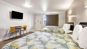 Una habitación de hotel con una cama, un escritorio, una silla y un televisor.