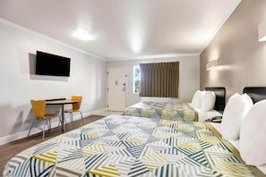 Une chambre d’hôtel équipée d’un lit, d’un bureau, d’une chaise et d’un téléviseur.
