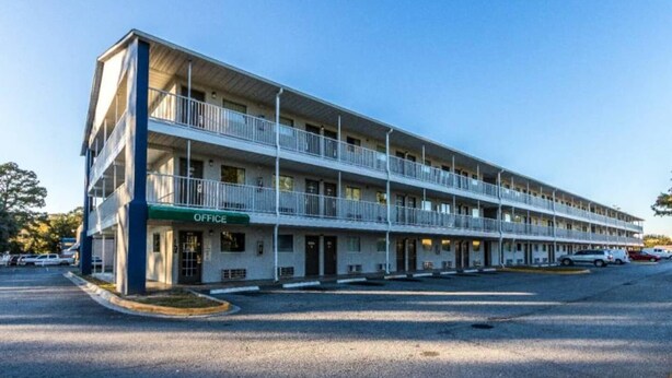 A multi-story motel with a green 'OFFICE' sign, multiple balconies, and a parking lot. - 1 queen bed | kitchen non-smoking (Savannah GA)