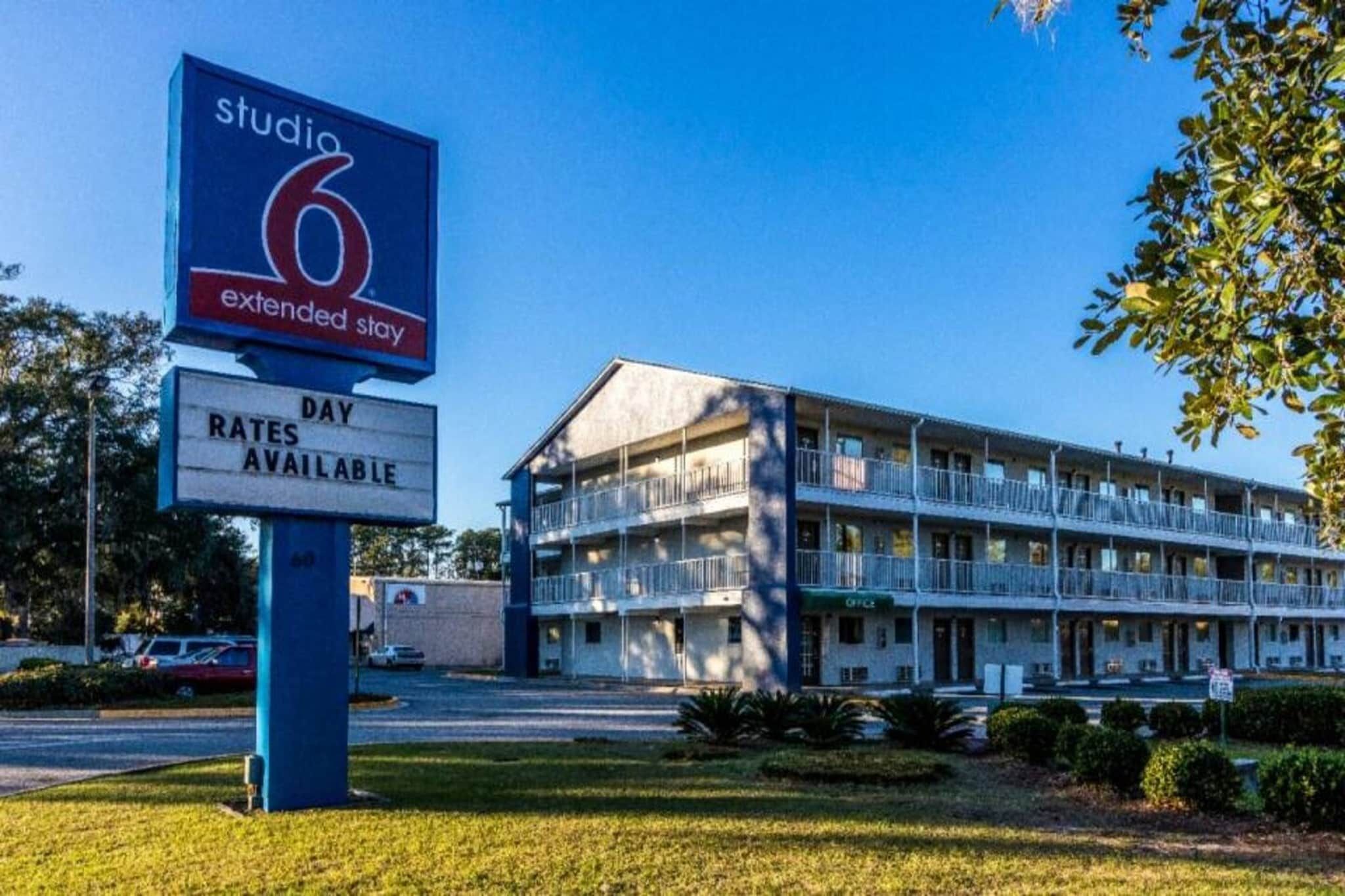 Un motel con un letrero que indica disponibilidad para estancias prolongadas y otro que muestra las tarifas.