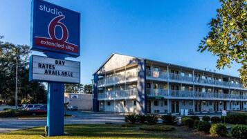 Un motel con un letrero que indica disponibilidad para estancias prolongadas y otro que muestra las tarifas.
