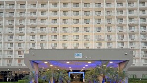 A multi-story hotel building with a prominent entrance and a sign indicating the address. - 2 Queen Beds|Suite,Nsmk,Micfridge (Inglewood)