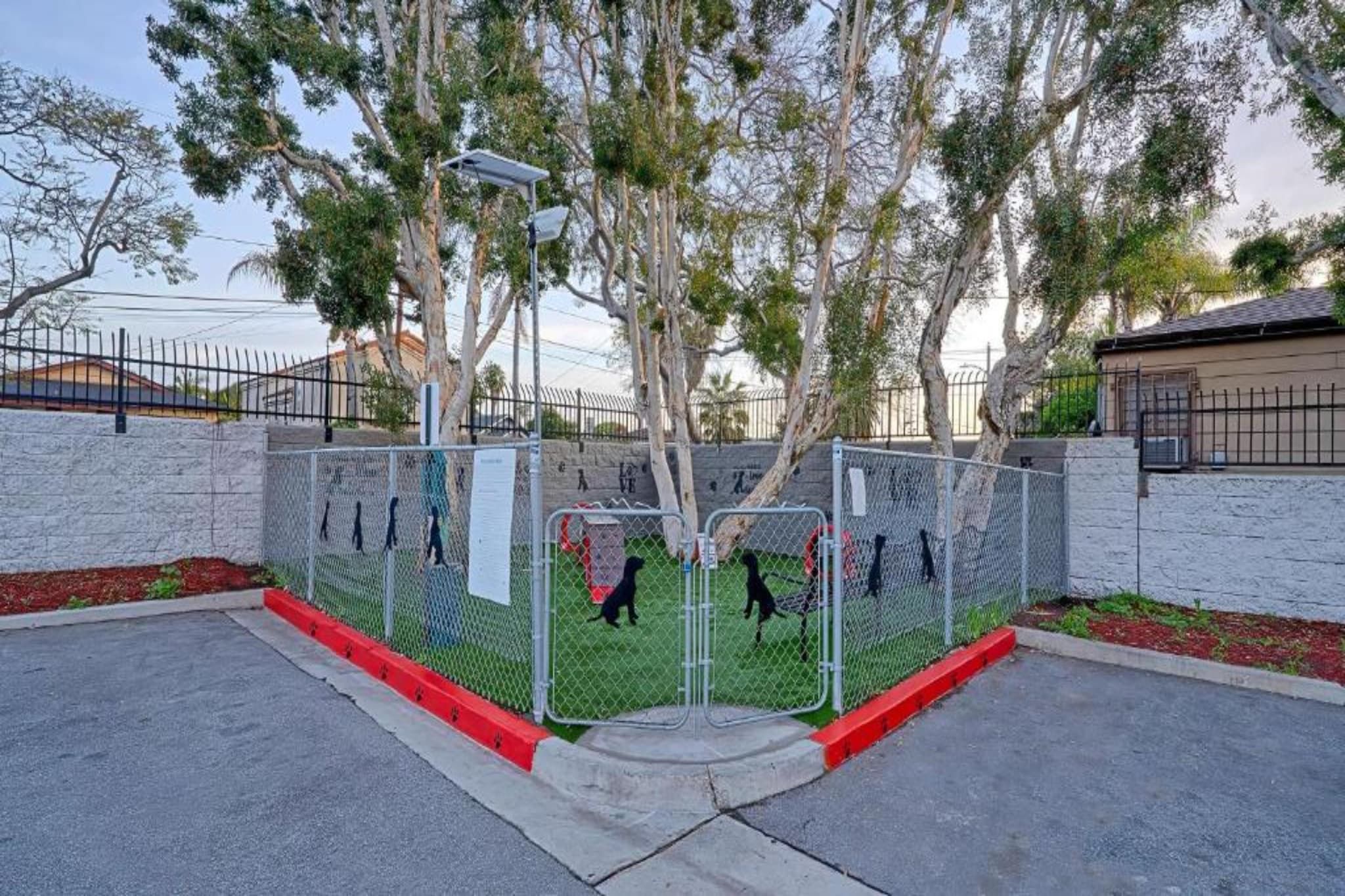 A fenced area with a street lamp and trees.