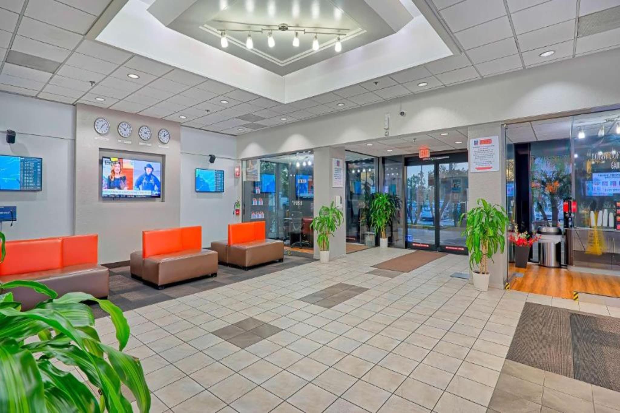 A lobby with seating areas, a reception desk, and a glass door entrance.