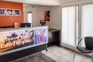 A hotel reception desk with a sign reading 'I'll leave the 6 on for you.'