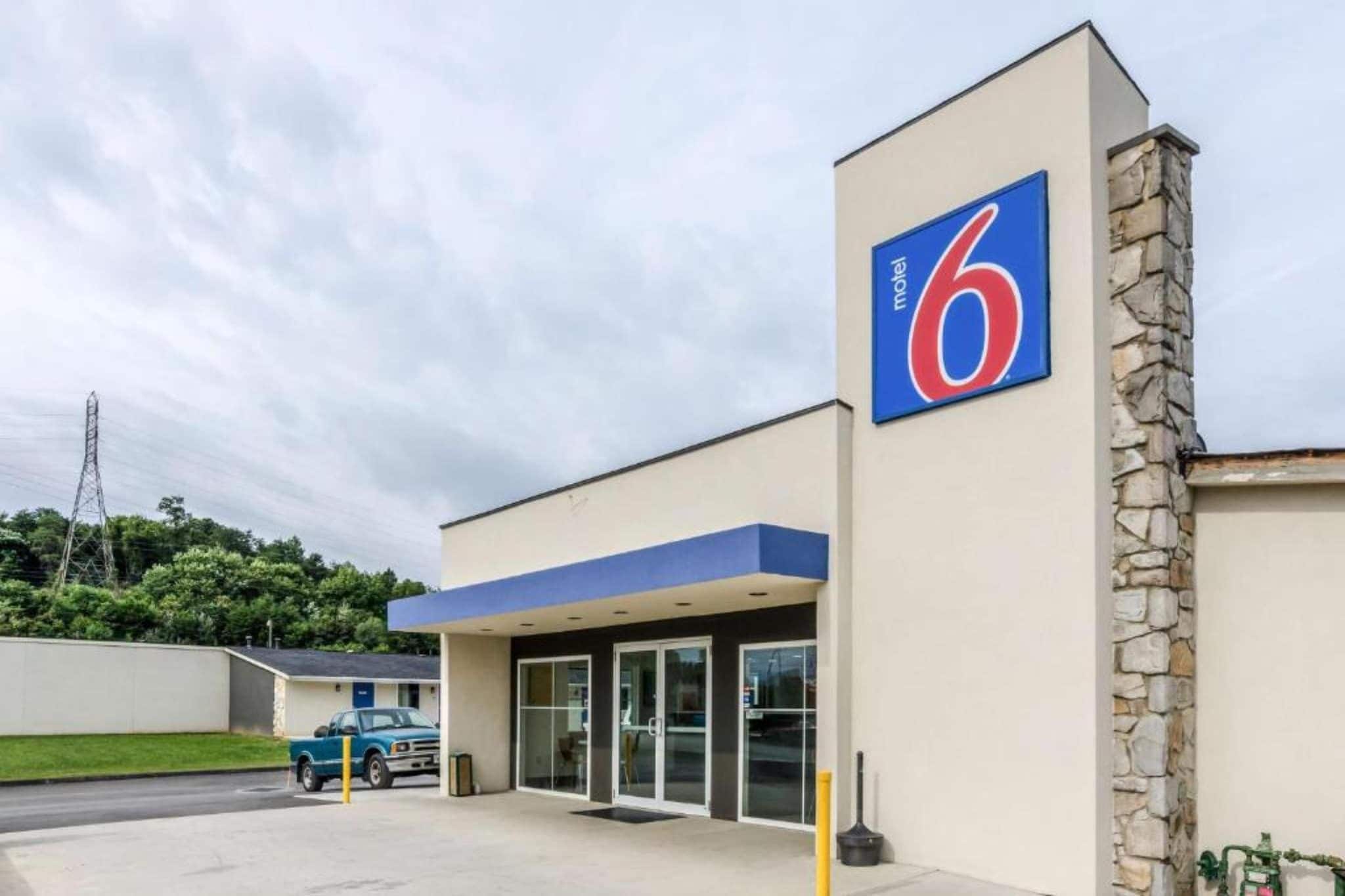 A motel with a prominent '6' sign, a drive-through entrance, and a stone facade.