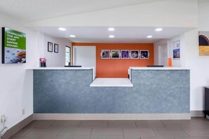 A reception area with a grey reception desk, a white counter, and a wall with framed pictures. - 1 KING BED | NON-SMOKING, KITCHEN (Troutville)