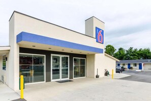 A motel with a blue awning, a large number '6' sign, and a parking lot. - 1 KING BED | NON-SMOKING, KITCHEN (Troutville)