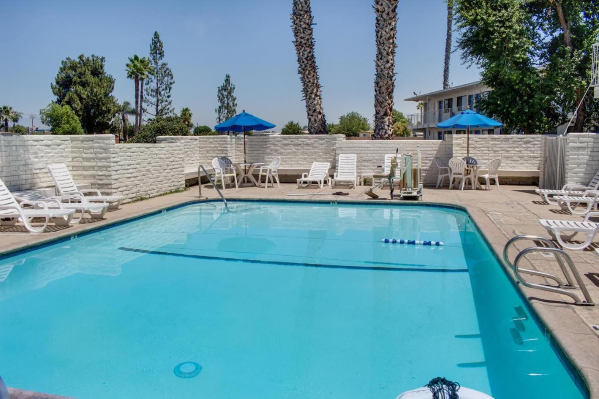 Una piscina con sillones de descanso y sombrillas.