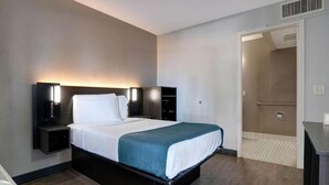 A hotel room with a bed, bedside tables, a wardrobe, and a bathroom door. - 1 Queen Bed | Non-Smoking, Micfridge (Bakersfield)