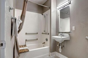 Un baño con bañera, ducha, lavamanos y espejo.