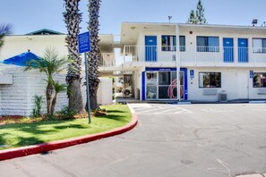 A building with a blue and white facade, a welcome sign, and a parking lot with marked spaces.