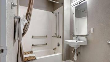 Een badkamer met een bad, een douche, een wastafel en een spiegel.