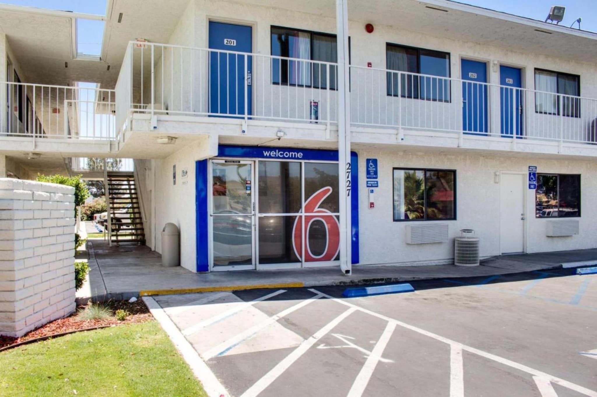 Un edificio con una entrada azul que dice 'Welcome' y el número '6' en la puerta.