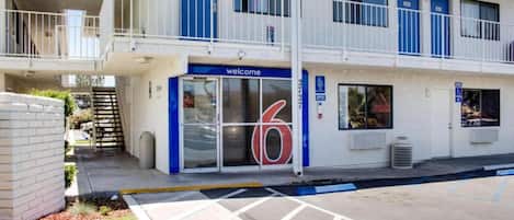 Un edificio con una entrada azul que dice 'Welcome' y el número '6' en la puerta.