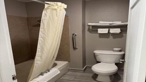 Un baño con ducha, inodoro y toallero.