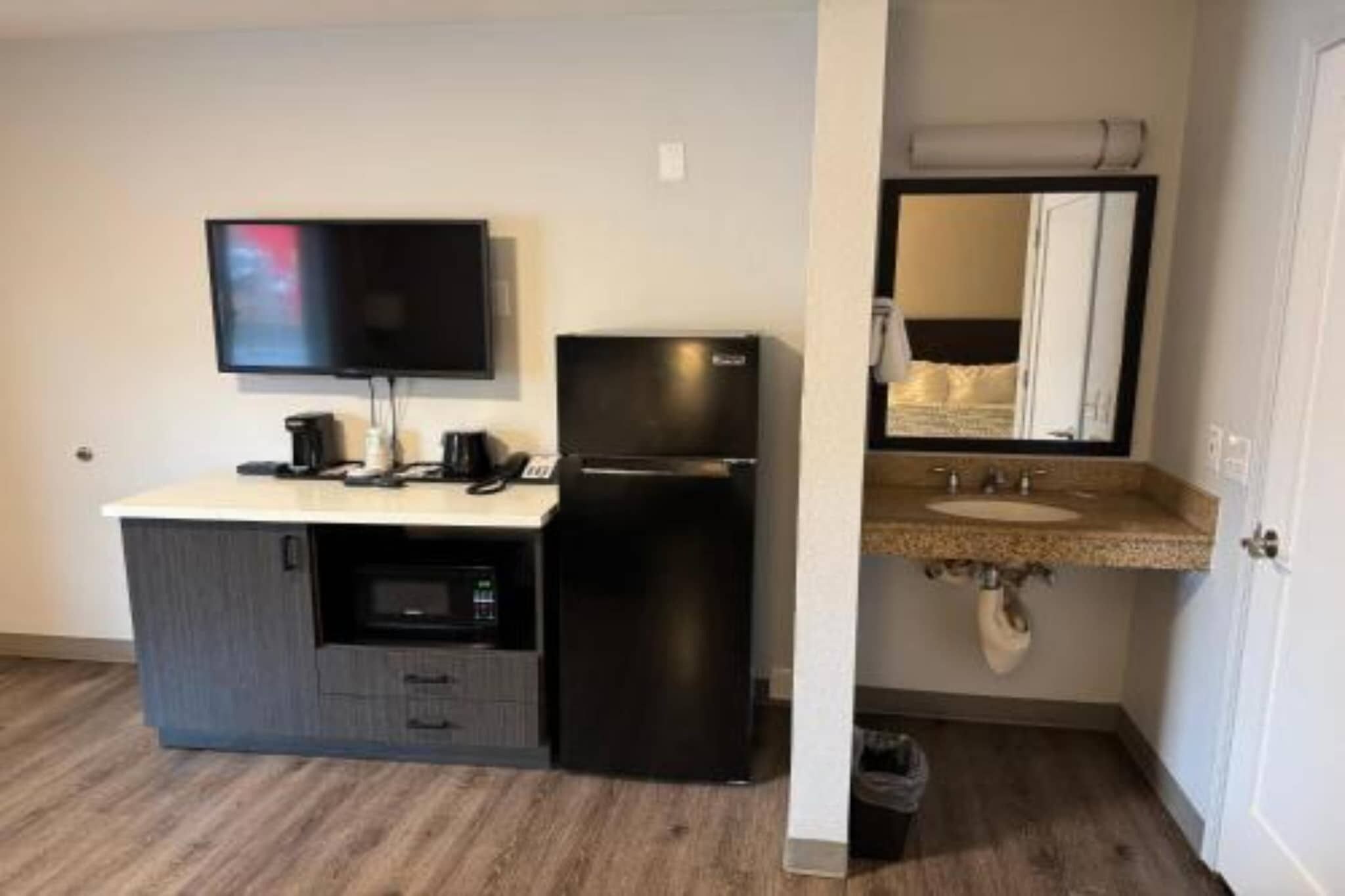 Une kitchenette équipée d’un téléviseur à écran plat, d’un réfrigérateur, d’un four à micro-ondes et d’une machine à café.