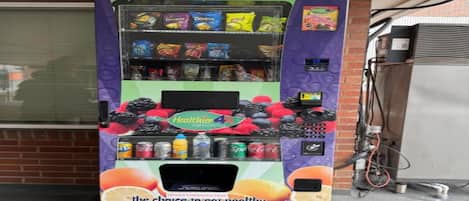 A vending machine with a variety of snacks and drinks, including a prominent display of fruit juices.