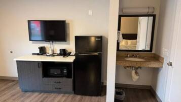 Une kitchenette équipée d’un téléviseur à écran plat, d’un réfrigérateur, d’un four à micro-ondes et d’une machine à café.