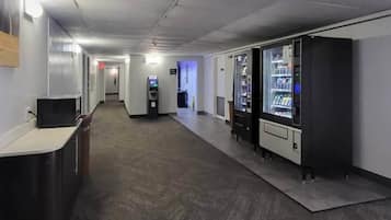 Un couloir avec des distributeurs automatiques, un comptoir d’accueil et une caméra de surveillance fixée au plafond.
