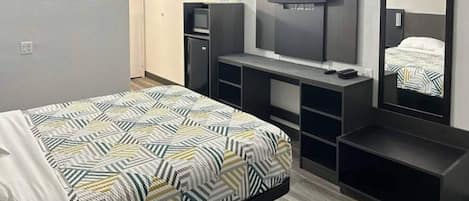 Una habitación de hotel con cama, televisión, escritorio y armario.