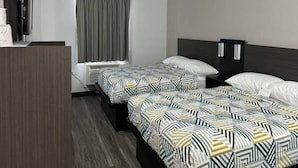 Hotellihuone, jossa on kaksi sänkyä, televisio, ikkuna verhoilla ja vaatekaappi.
