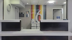 Aula, jonka seinässä on suuri numero 6, seinäkello ja kyltti, joka ilmoittaa alennusmyynnistä.