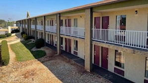 Motel amb una filera d'habitacions, cadascuna amb un balcó i una porta.