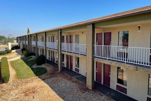 A motel with a row of rooms, each with a balcony and a door. - 1King Bed|Smoking, Micfridge (Stockbridge)