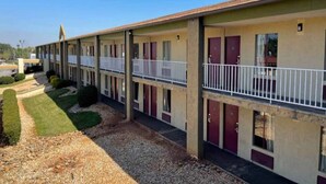 Motel amb una filera d'habitacions, cadascuna amb un balcó i una porta.