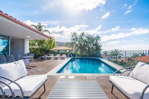 A swimming pool with lounge chairs and a covered patio area. - Vila Bela by Your Madeira Rentals (Arco da Calheta)