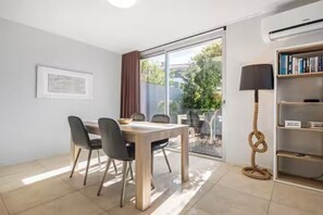 A dining area with a table and chairs, a bookshelf, and a rope swing. - Vila Bela by Your Madeira Rentals (Arco da Calheta)