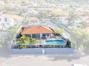 A residential property with a swimming pool, a covered patio, and a view of the surrounding neighborhood. - Vila Bela by Your Madeira Rentals (Arco da Calheta)