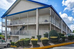 A multi-story building with balconies, a staircase, and a parking area. - Comfy 2 FULL BEDS | NON-SMOKING (Atlanta)