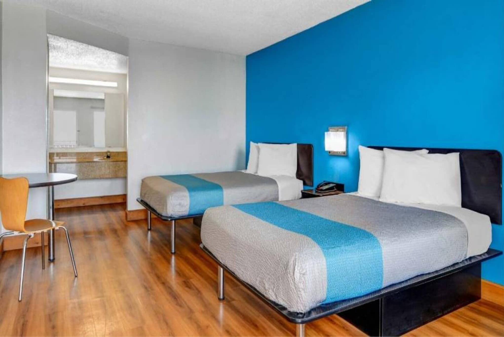 Una habitación de hotel con dos camas, un escritorio y una silla.