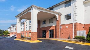 A multi-story hotel with a covered entrance and a parking lot. - 1 King Bed | Smoking, Micfridge (Jonesboro)