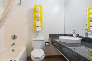 Et moderne badeværelse med badekar, toilet og håndvask.