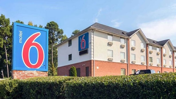 A motel with a prominent '6' sign, a brick facade, and multiple windows. - 1 King Bed | Smoking, Micfridge (Jonesboro)