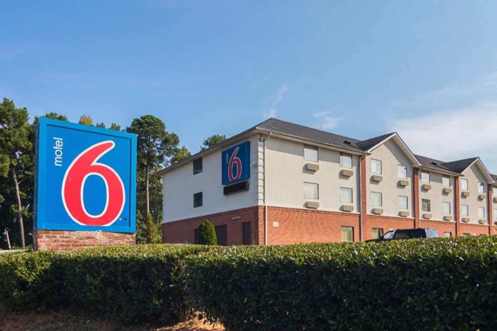 A motel with a prominent '6' sign, a brick facade, and a row of windows.