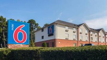 A motel with a prominent '6' sign, a brick facade, and a row of windows.