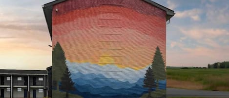 A building with a mural of a sunset and mountains.