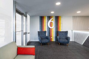 A modern waiting area with two armchairs, a red cushion, and a large number '6' on the wall. - 2 Queen Beds | Non-Smoking, Kitchen (Hickory)
