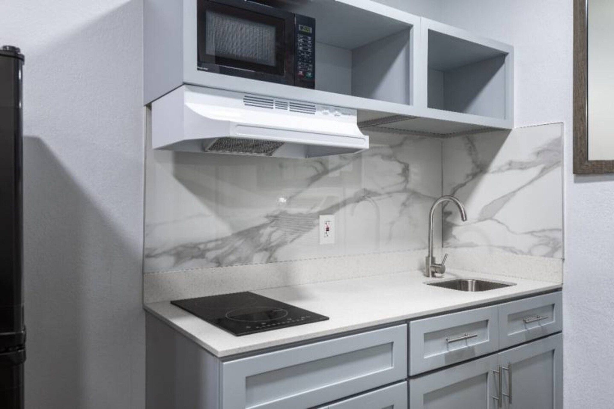 A kitchen with a built-in microwave, stove, and sink.