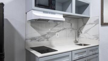 A kitchen with a built-in microwave, stove, and sink.