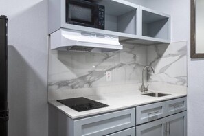 A kitchen with a built-in microwave, stove, and sink.