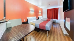 A hotel room with two beds, a wooden table, and a TV. - 2 Full Beds|Smk,Mini Fridge (Fort Worth)