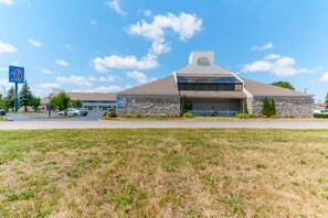 A motel with a stone facade, a large garage, and a parking lot. - 1 King Bed | Non-Smoking (Southgate)