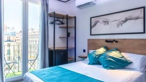 Quarto de hotel com cama, janela e varanda.